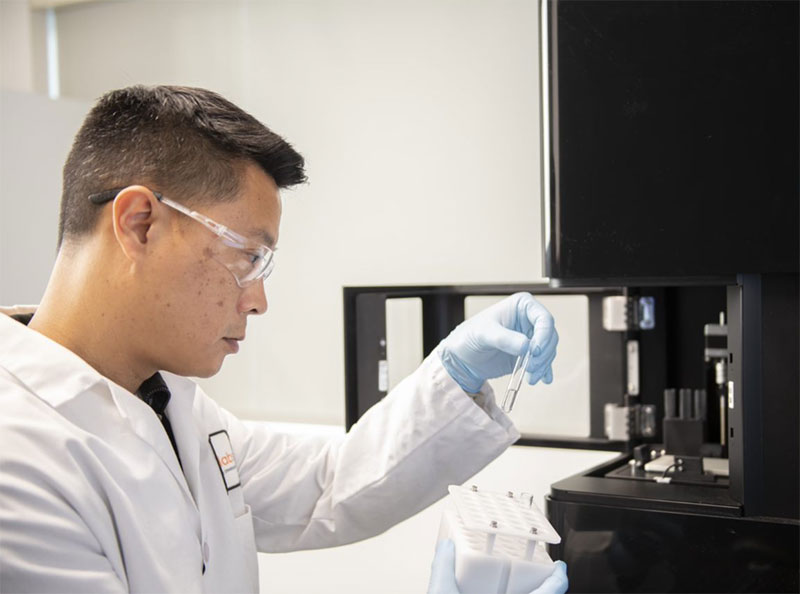 Sony ID700 cell analyzer with operator in lab coat holding a test tube