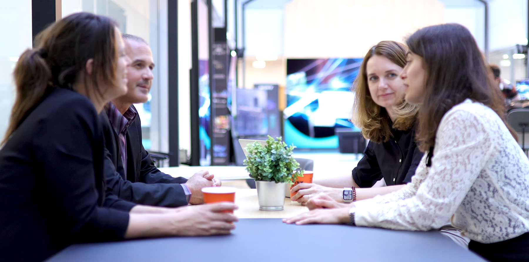 Business meeting with four individuals gathered around a conference table